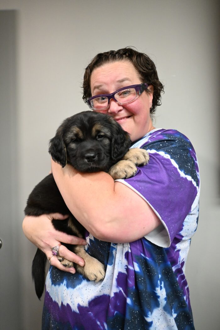 Woman looking happy holding puppy